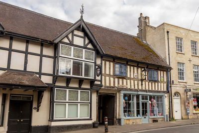 Houses by street in city against sky