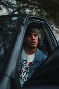 Portrait of young man sitting in car