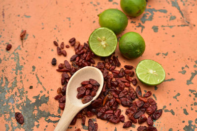 Cool green limes hot red dried chili peppers on tabletop 