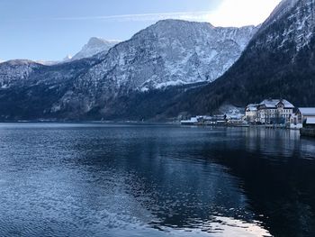 Scenic view of lake by snowcapped mountains against sky