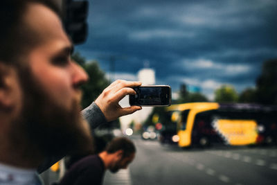 Reflection of man photographing on mobile phone