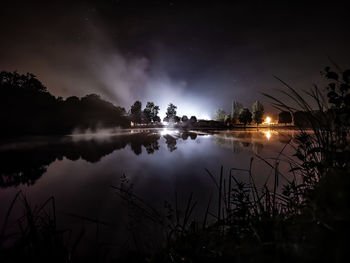 Scenic view of lake against sky at night