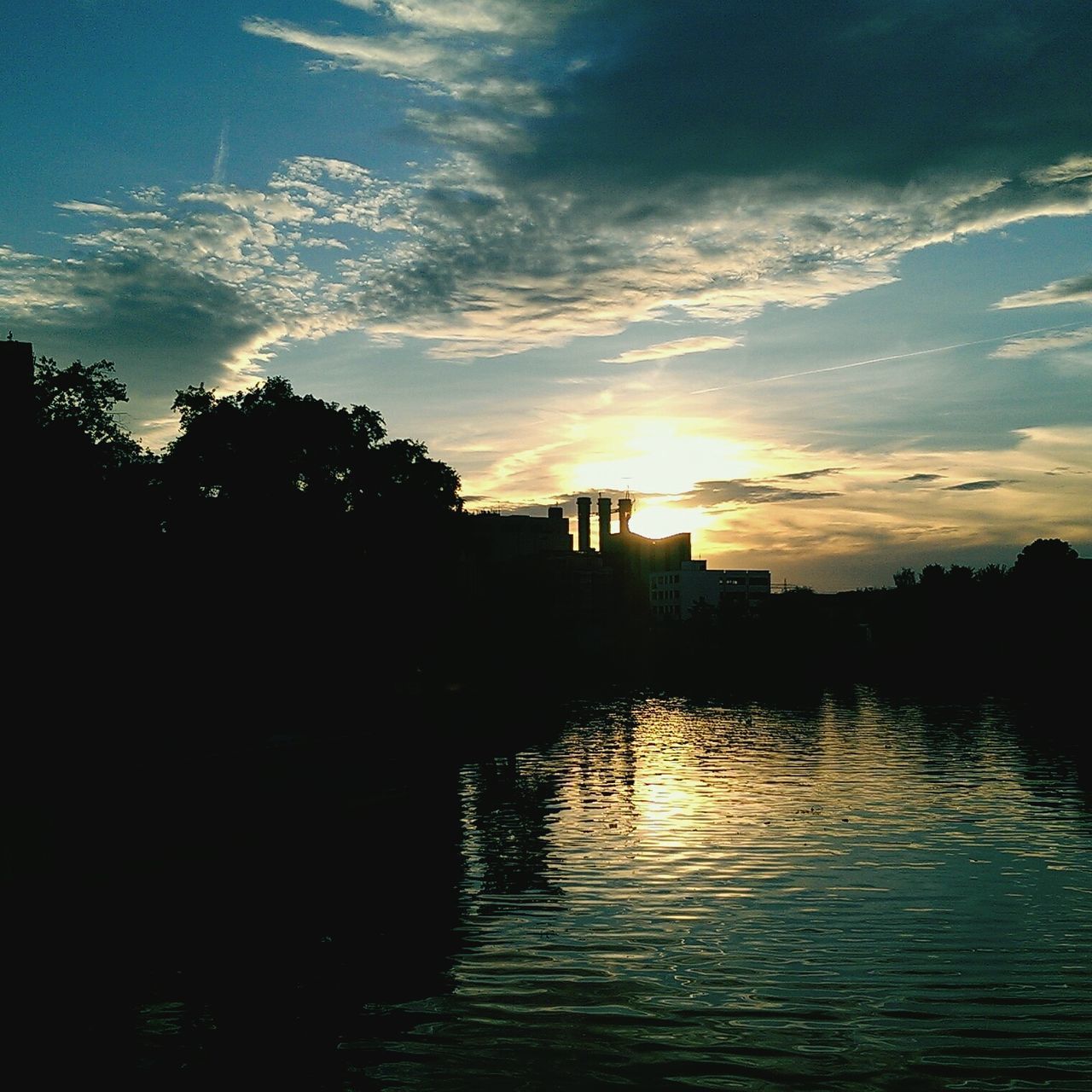 sunset, silhouette, sky, water, waterfront, building exterior, reflection, scenics, built structure, cloud - sky, river, architecture, beauty in nature, tranquility, tree, tranquil scene, city, sun, nature, lake