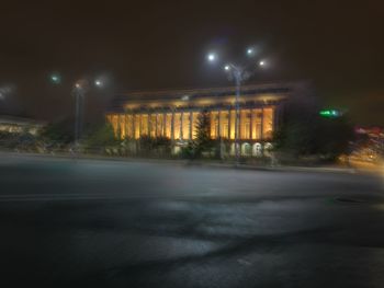 Illuminated road against sky at night