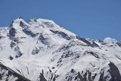 Scenic view of snowcapped mountains against clear sky