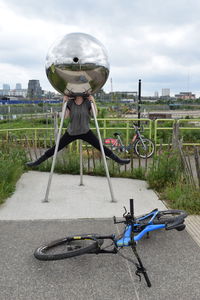 Bicycle on road in city against sky