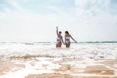 People at beach against sky