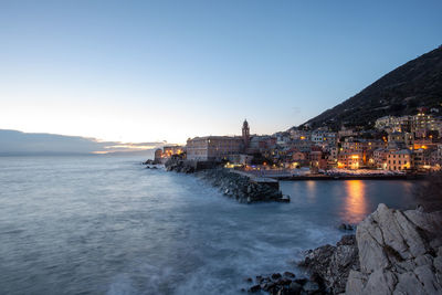 Scenic view of sea and buildings against clear sky