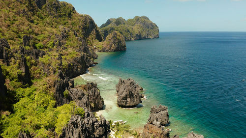 Tropical lagoon with sandy beach surrounded by cliffs. el nido, philippines, palawan. 