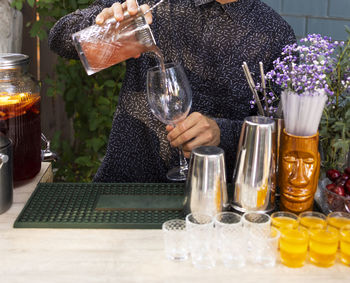 Rear view of woman drinking glass on table