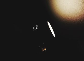 Close-up of illuminated lighting equipment against black background