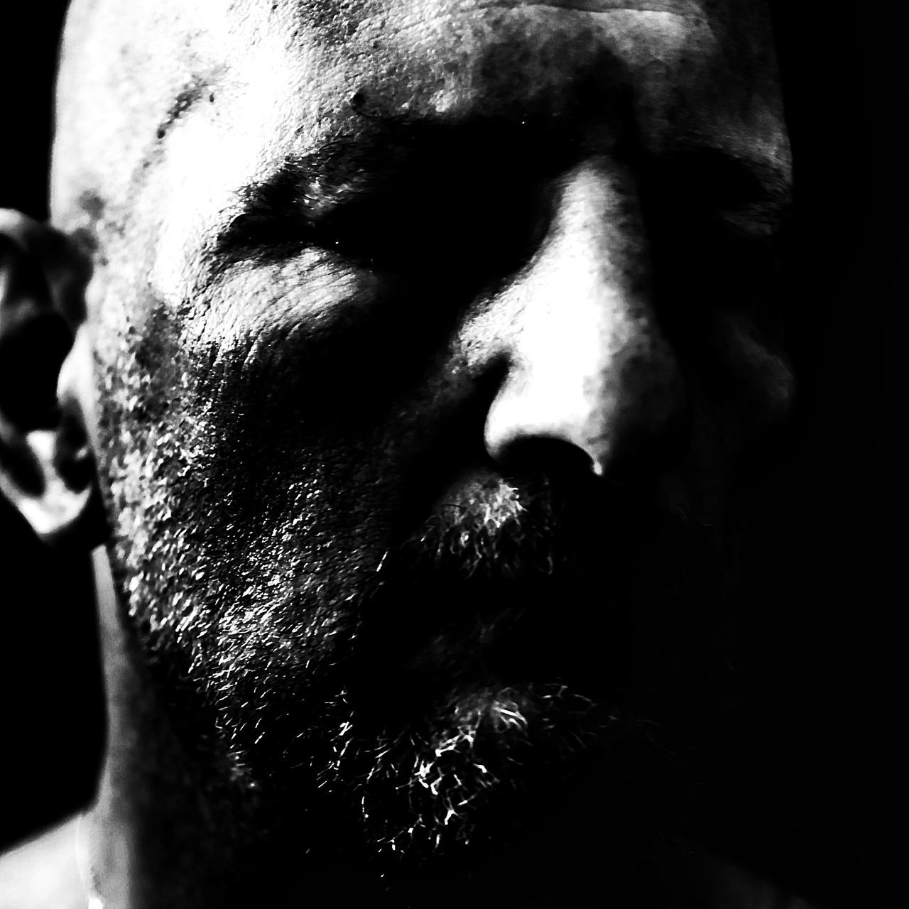 one person, portrait, black, adult, beard, close-up, black and white, facial hair, headshot, men, human face, darkness, monochrome, monochrome photography, black background, indoors, serious, lifestyles, studio shot, front view, negative emotion, dark, eyes closed, emotion