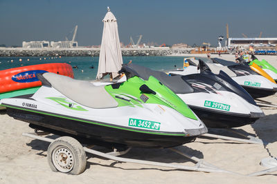 Boats moored on beach against sky