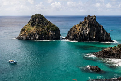 Panoramic shot of rocks in sea against sky