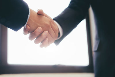 Close-up of lawyer shaking hands in courtroom