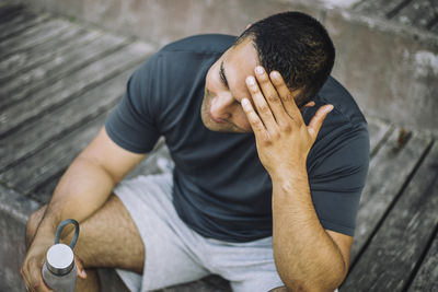 Tired man with head in hand while sitting on steps