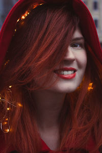 Close up smiling person with red hair and fairy lights portrait picture