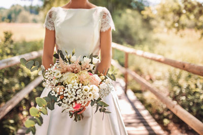 Midsection of woman holding flower bouquet