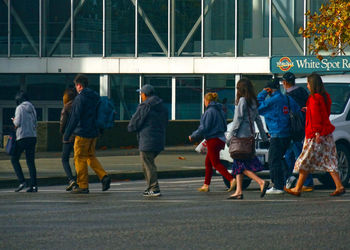 People walking on zebra crossing in city