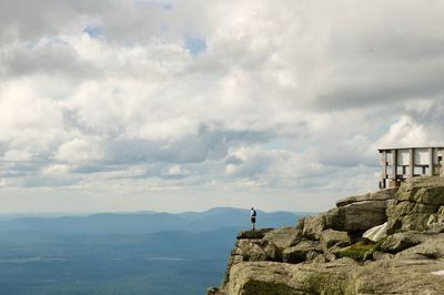 Man standing on cliff against sky