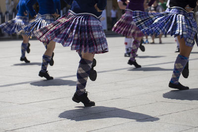 Low section of women dancing on footpath