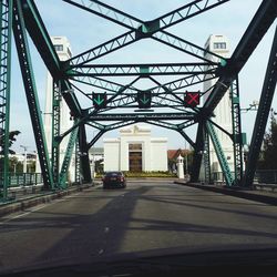 Cars on road against sky in city