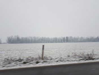 Scenic view of snow covered land against sky