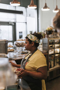 Side view of a woman standing in store