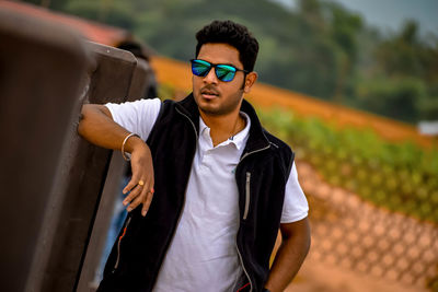 Young man wearing sunglasses standing outdoors