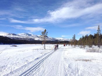 People on snowcapped mountain against sky