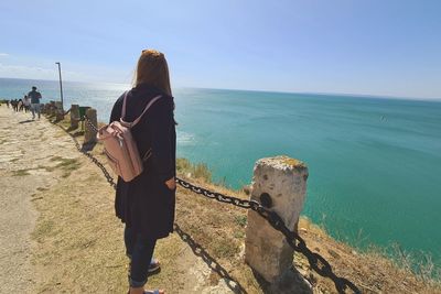 Rear view of woman looking at sea against sky