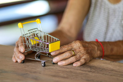 Midsection of man using mobile phone at store