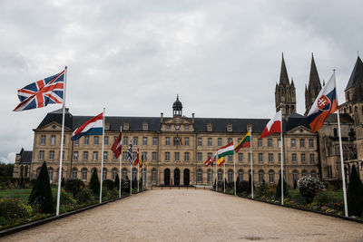 Flag on building against cloudy sky