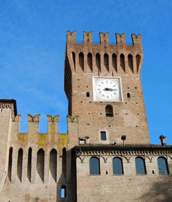 Low angle view of old building against blue sky