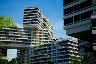 Low angle view of modern buildings against clear blue sky