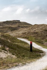 Road amidst field against sky