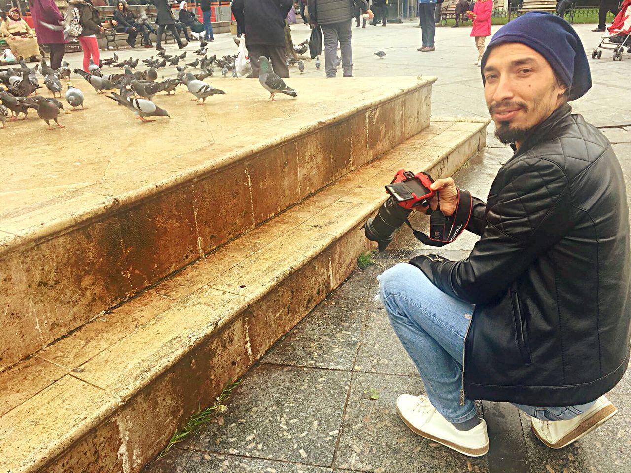 MAN SITTING IN A CITY