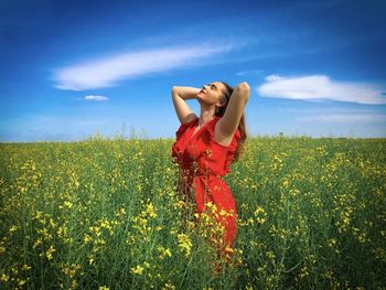 Woman in red dress in a field of canola