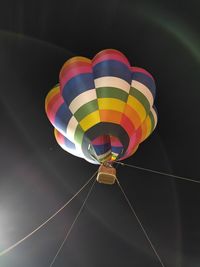 Low angle view of hot air balloons flying against sky at night