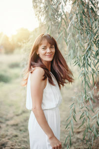 Portrait of smiling woman by tree