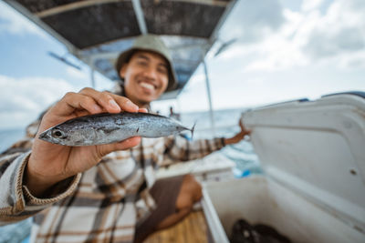 Cropped hand of person holding fish