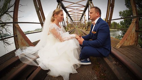 Young couple holding hands sitting outdoors