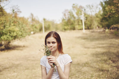 Portrait of a smiling young woman on field