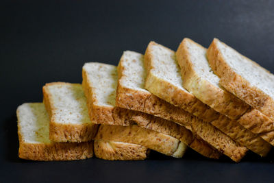 Close-up of bread on table against black background