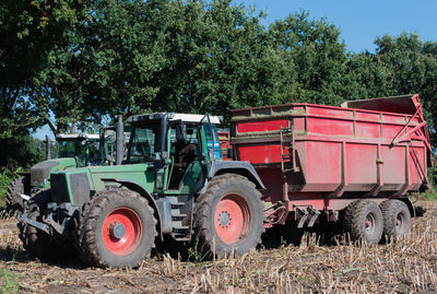 Tractor on field against trees