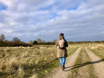 Rear view of man walking on field