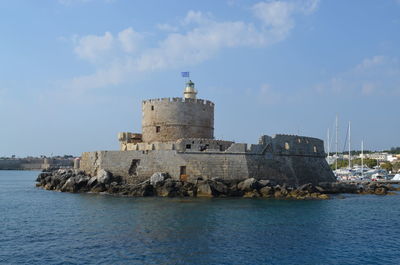 Castle by sea against sky