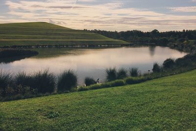 Scenic view of lake against cloudy sky