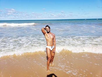 Portrait of shirtless man standing at beach