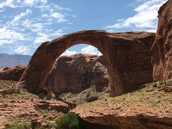 Rock formation by mountain against sky